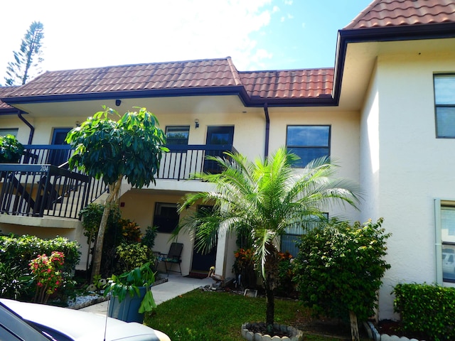 exterior space featuring stucco siding and a tiled roof