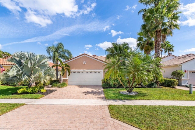 mediterranean / spanish-style house with stucco siding, a tiled roof, an attached garage, decorative driveway, and a front yard