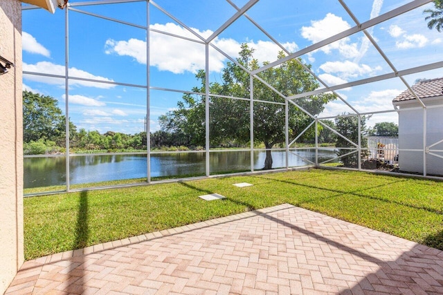 view of patio / terrace featuring a lanai and a water view