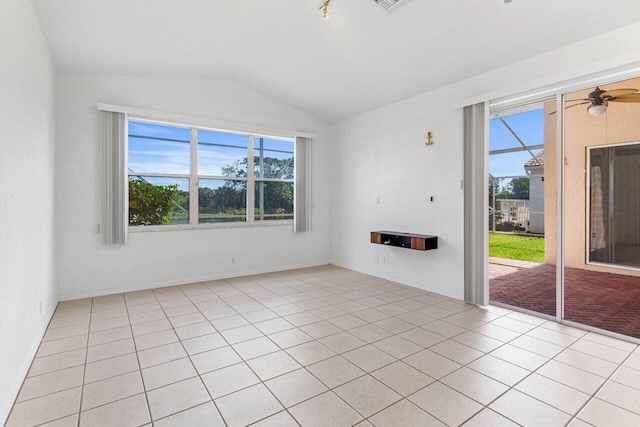 unfurnished room with lofted ceiling, visible vents, ceiling fan, and light tile patterned floors