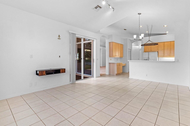 unfurnished living room with light tile patterned floors, visible vents, and an inviting chandelier