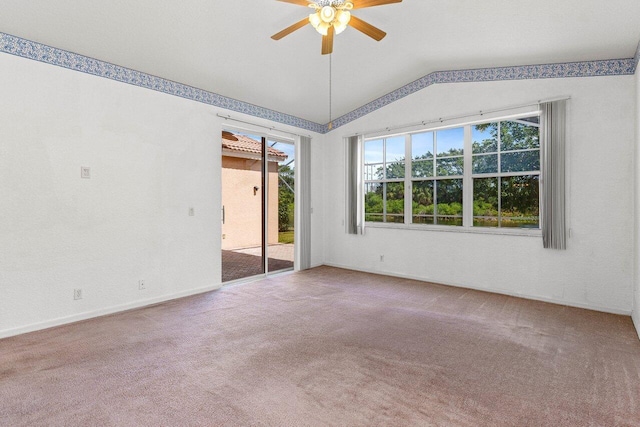 carpeted spare room featuring a ceiling fan and vaulted ceiling