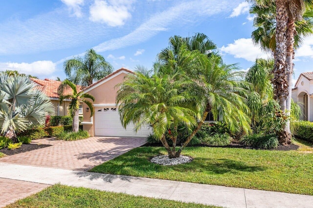 view of front of property with a garage, a front lawn, decorative driveway, and stucco siding