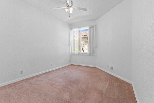 empty room featuring light carpet, baseboards, a textured wall, ceiling fan, and a textured ceiling