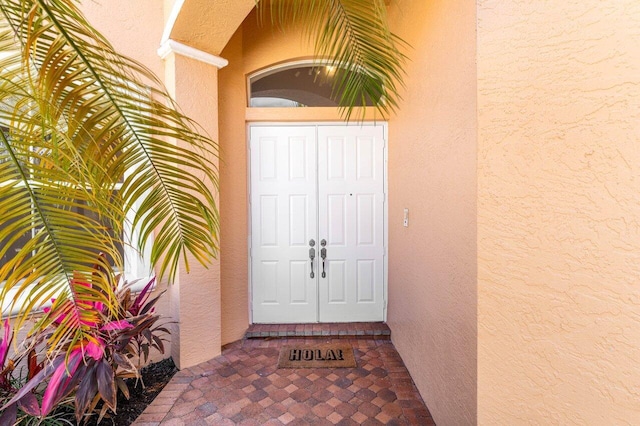 doorway to property featuring stucco siding