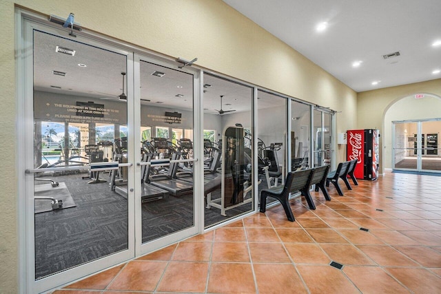 gym featuring arched walkways, recessed lighting, visible vents, a ceiling fan, and tile patterned flooring