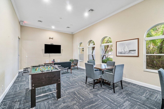 rec room featuring visible vents, dark carpet, and crown molding