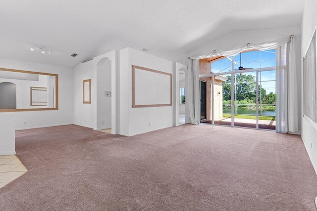 unfurnished living room with vaulted ceiling and carpet floors