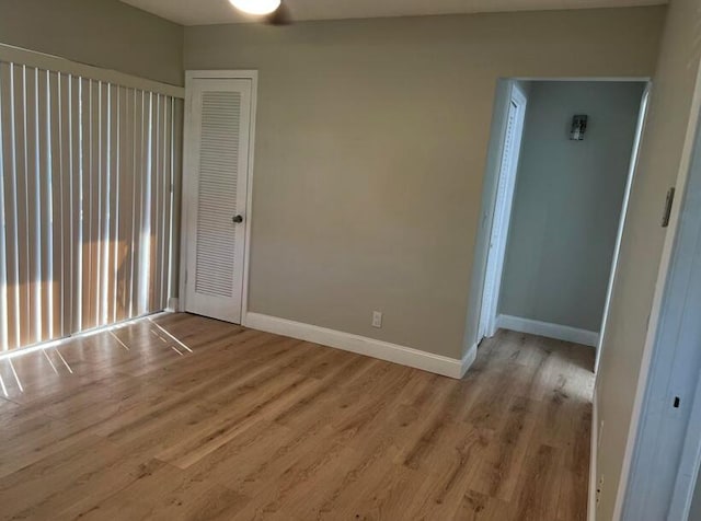 empty room with light wood-style flooring and baseboards