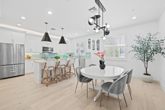 dining room featuring a notable chandelier, recessed lighting, visible vents, light wood-style floors, and crown molding