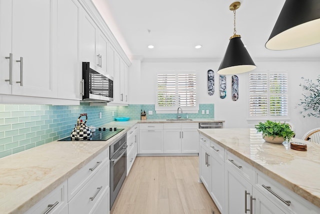 kitchen with crown molding, stainless steel appliances, tasteful backsplash, white cabinetry, and a sink