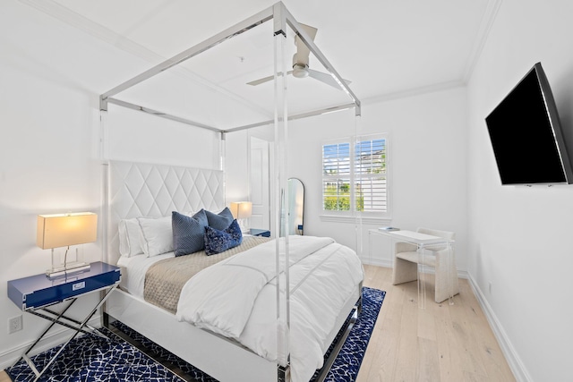 bedroom featuring light wood-style floors, baseboards, ornamental molding, and a ceiling fan