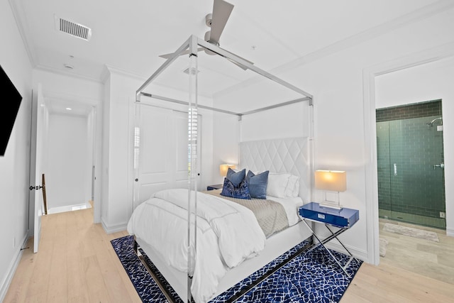 bedroom featuring a closet, visible vents, light wood-style flooring, ornamental molding, and baseboards