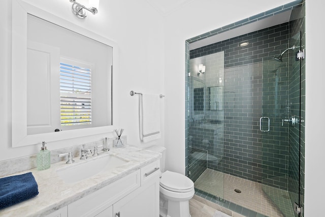 bathroom with a stall shower, vanity, and toilet