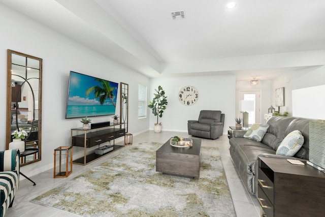 living area featuring a wealth of natural light, visible vents, baseboards, and tile patterned floors