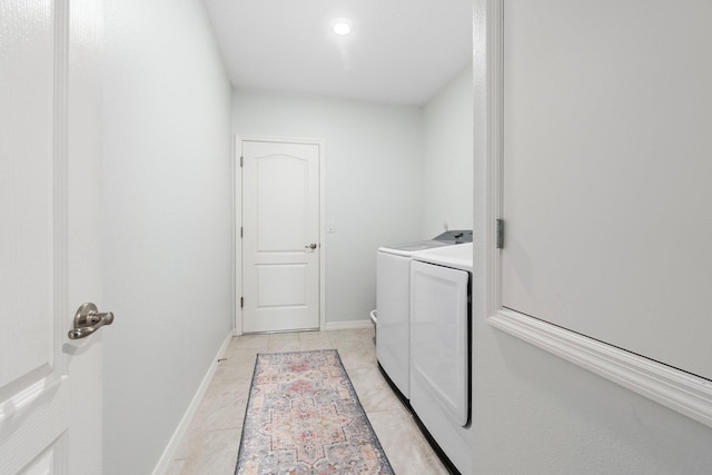 laundry area featuring laundry area, light tile patterned flooring, baseboards, and washing machine and clothes dryer