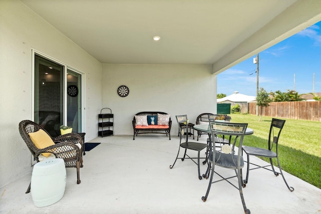 view of patio featuring outdoor dining space and fence