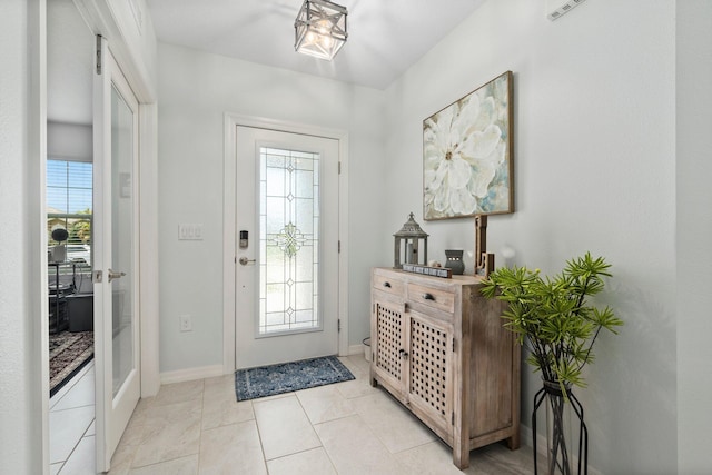 entryway featuring light tile patterned floors and baseboards