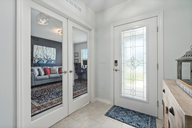 foyer featuring light tile patterned floors, baseboards, visible vents, and french doors