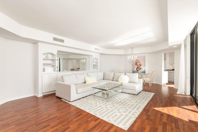 living area featuring visible vents, baseboards, a notable chandelier, and dark wood finished floors