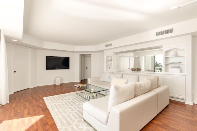 living area with visible vents, baseboards, and wood finished floors