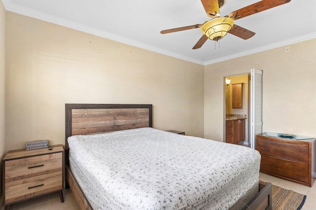 bedroom with crown molding, light tile patterned floors, a ceiling fan, and connected bathroom