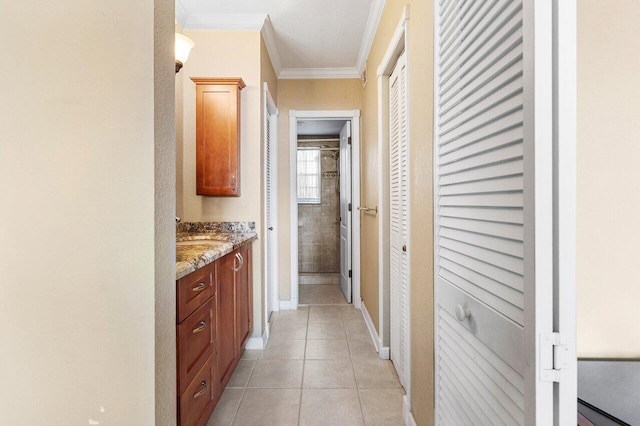 hall with light tile patterned floors, baseboards, and ornamental molding