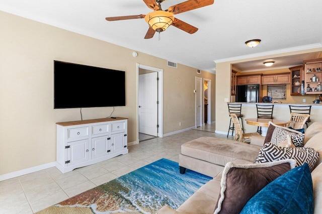 living area featuring light tile patterned flooring, a ceiling fan, visible vents, and baseboards