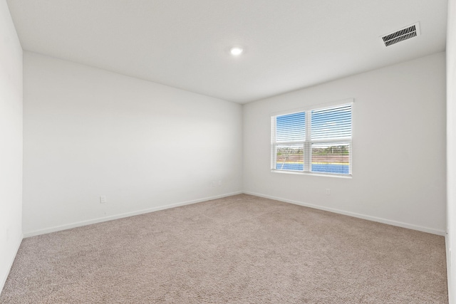 carpeted empty room featuring visible vents and baseboards