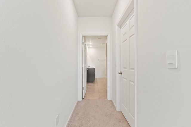 hallway with light carpet and baseboards