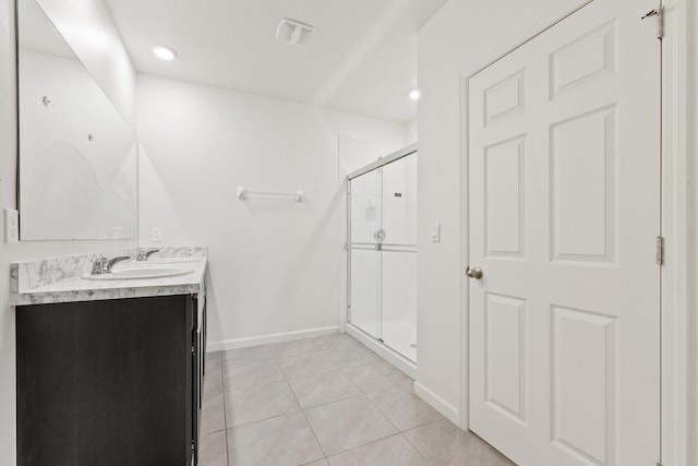 bathroom featuring a stall shower, visible vents, baseboards, tile patterned flooring, and vanity