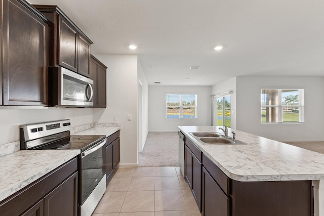 kitchen featuring a wealth of natural light, appliances with stainless steel finishes, a sink, and dark brown cabinetry