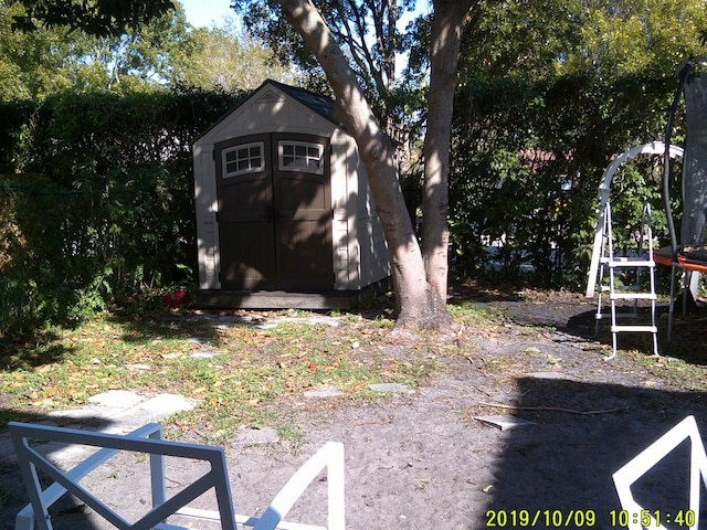 view of yard featuring a storage shed and an outdoor structure