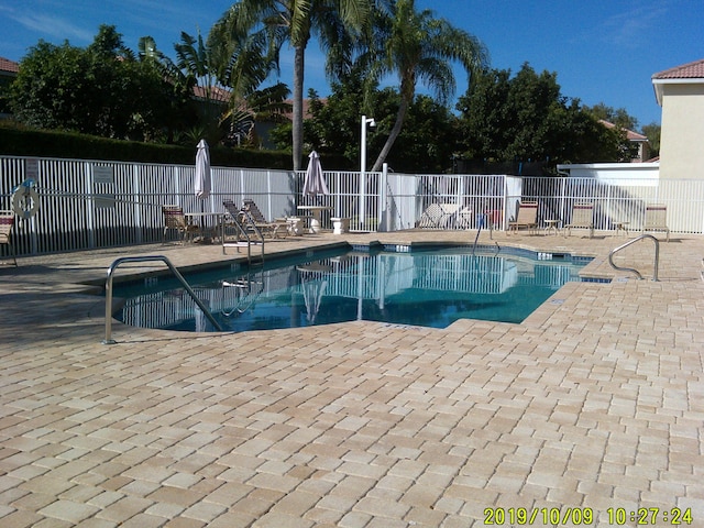 community pool with fence and a patio