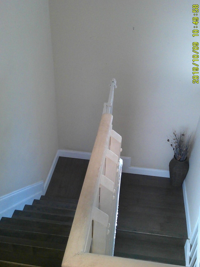 stairway with baseboards and wood finished floors