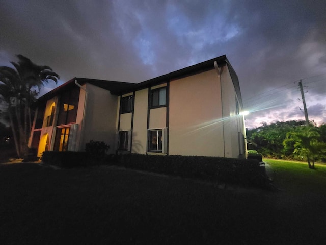 property exterior at dusk with stucco siding