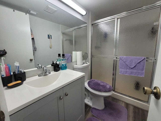 full bathroom with wood finished floors, toilet, a stall shower, and vanity