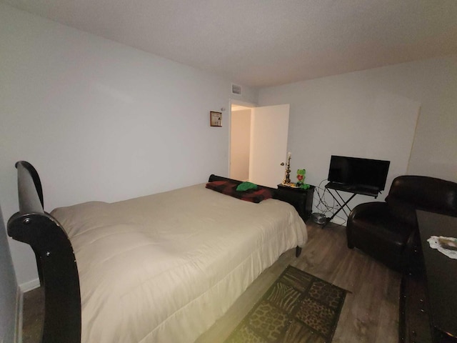 bedroom featuring visible vents and wood finished floors