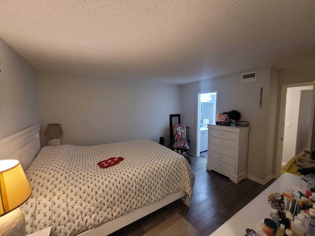 bedroom featuring visible vents, baseboards, dark wood-type flooring, and a textured ceiling