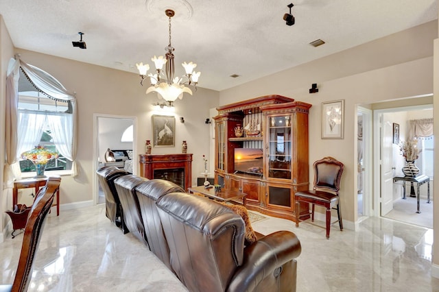 living area featuring marble finish floor, visible vents, a fireplace, and a textured ceiling