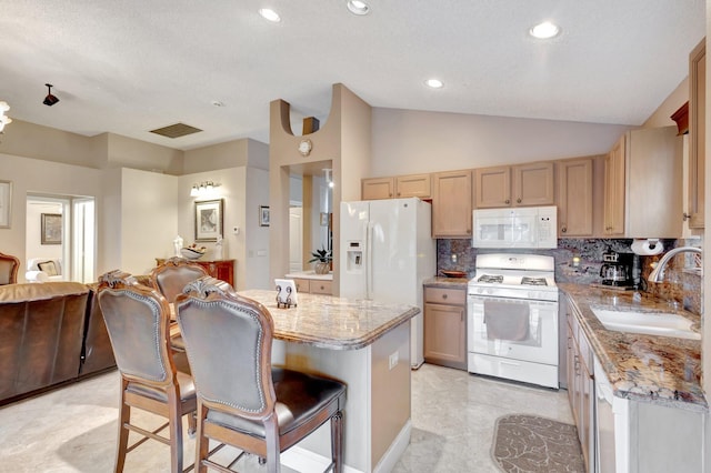 kitchen with white appliances, lofted ceiling, a center island, a sink, and backsplash