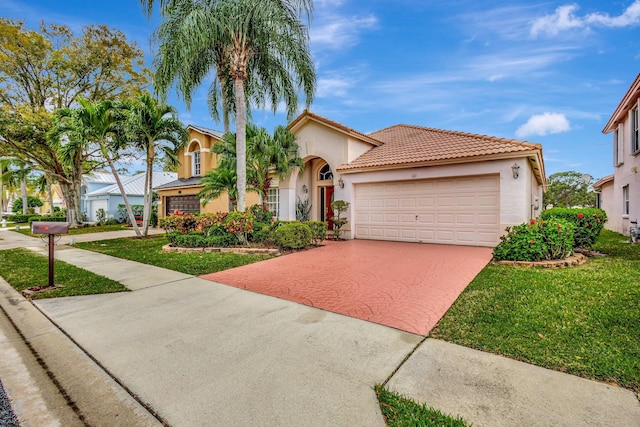 mediterranean / spanish-style home featuring a front yard, decorative driveway, an attached garage, and stucco siding