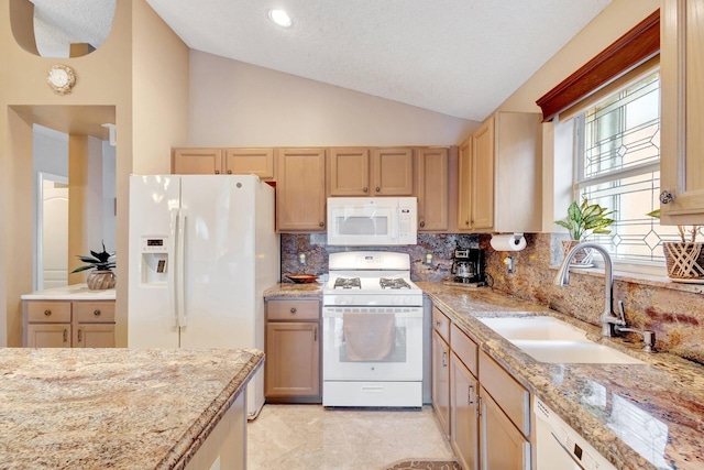 kitchen with white appliances, decorative backsplash, light stone countertops, vaulted ceiling, and a sink