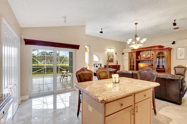 kitchen with a breakfast bar, an inviting chandelier, open floor plan, and a textured ceiling