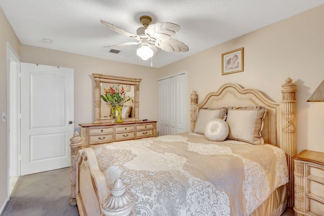 carpeted bedroom with ceiling fan, a closet, a textured ceiling, and visible vents