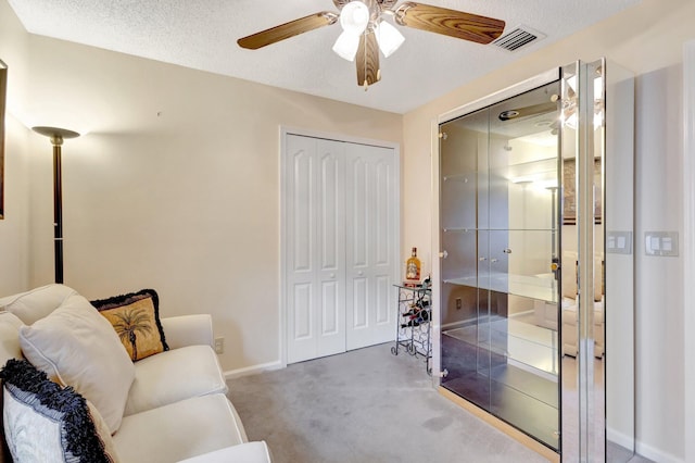 living area with carpet floors, baseboards, visible vents, and a textured ceiling