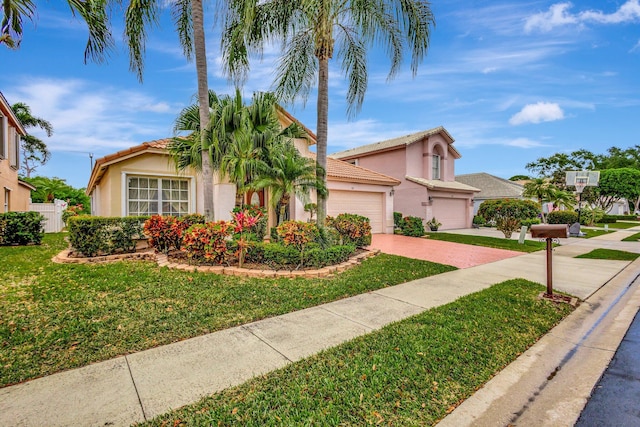 view of front of house featuring a tile roof, stucco siding, a garage, driveway, and a front lawn