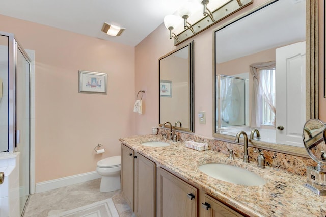 bathroom with toilet, a stall shower, and a sink