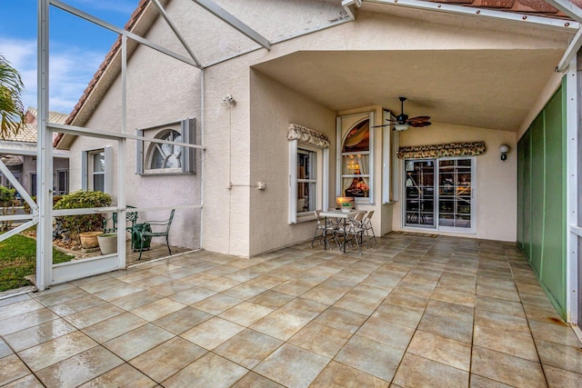 view of patio with glass enclosure and ceiling fan