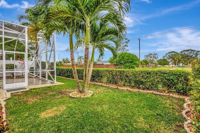 view of yard featuring a patio area, fence, and a lanai